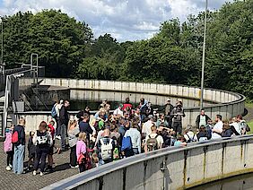 Viele Besucher stehen am Rand der Kläranlage bei einem Vortrag