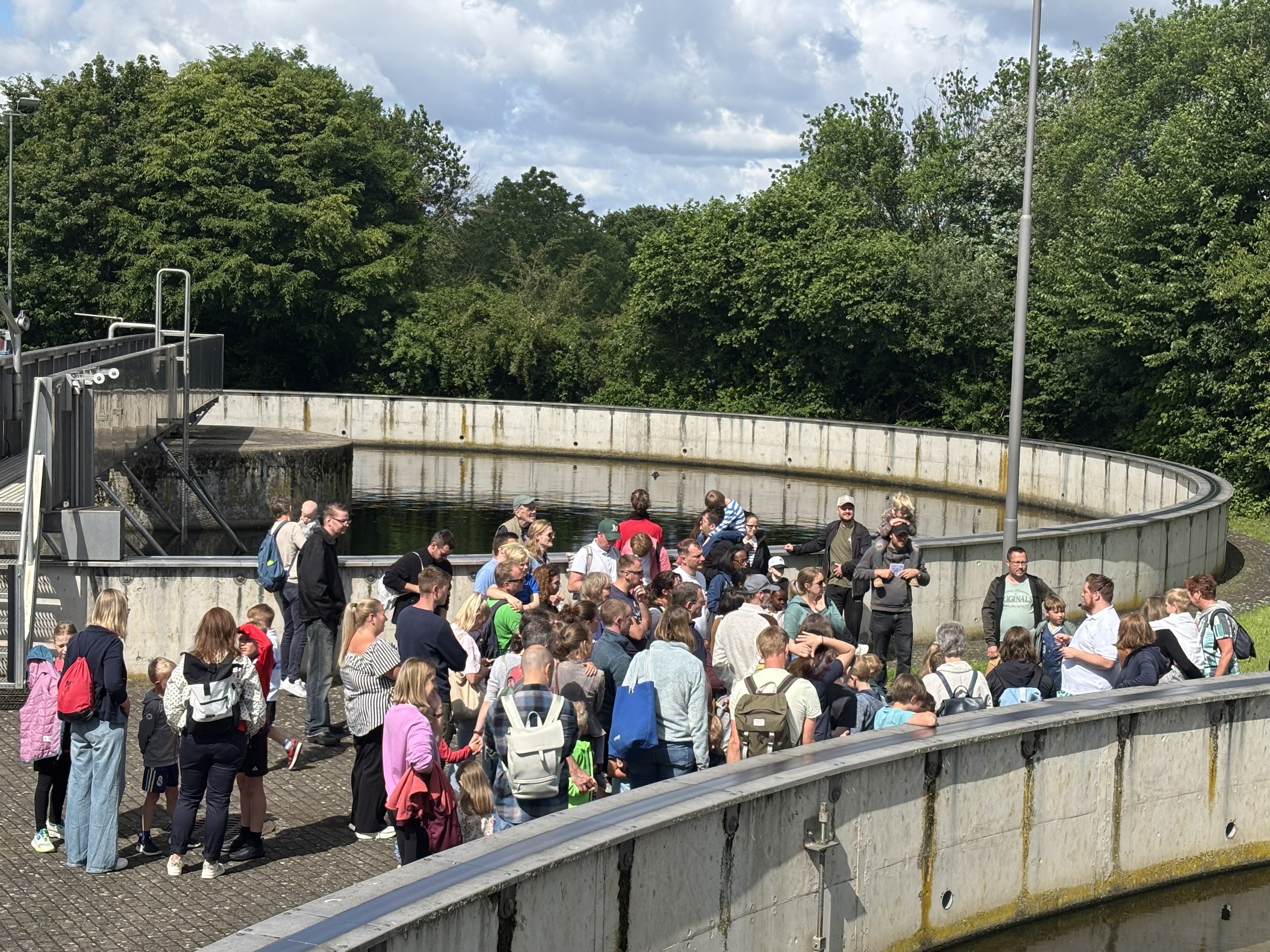 Viele Besucher stehen am Rand der Kläranlage bei einem Vortrag